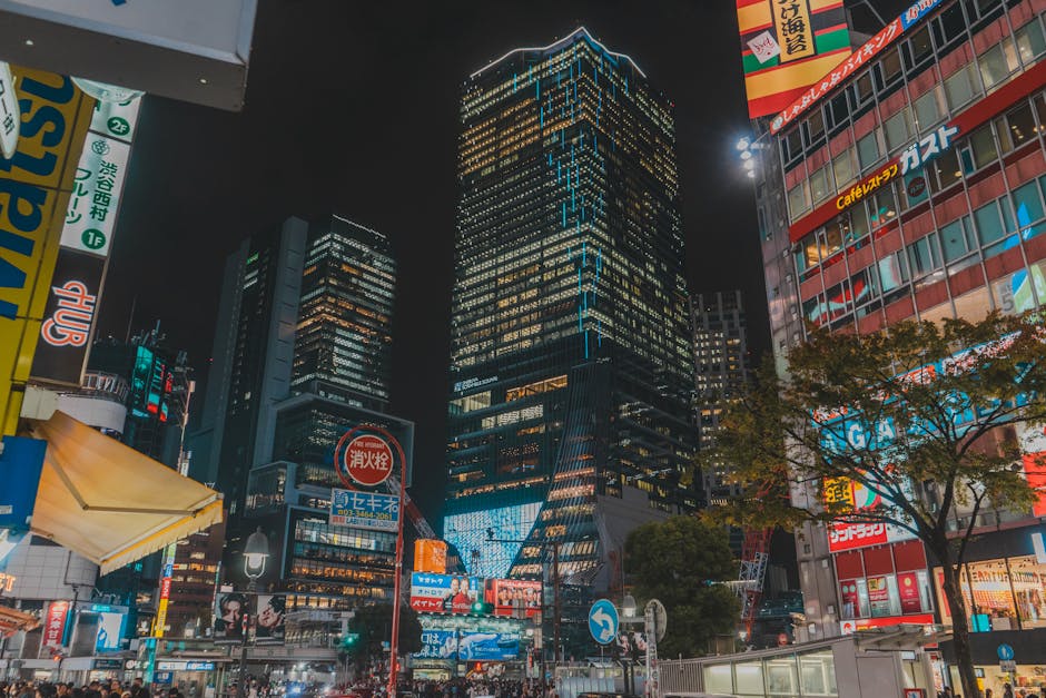 Night scene of Tokyo with illuminated skyscrapers and bustling street life, showcasing vibrant city energy.