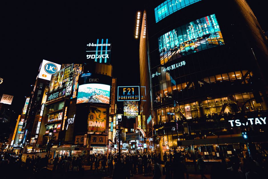 Explore the buzzing nightlife at Shibuya Crossing, Tokyo, with neon lights and bustling crowds.